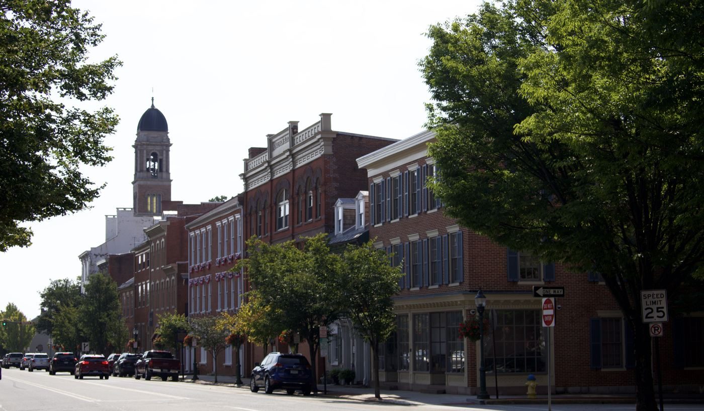 Brick storefronts along High Street in downtown Carlisle, with a cupola in the distance